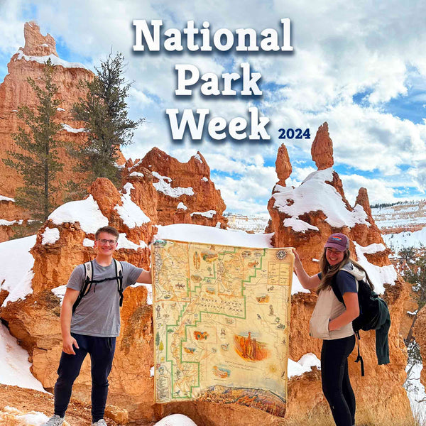 Winter Setting: A man and women holding open a Bryce Canyon National Park fleece blanket. They are standing on the rim of a cliff of Bryce Canyon. 