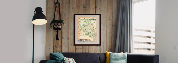 North Cascades National Park hand-drawn map hanging on a natural wood accent wall over a black couch. 