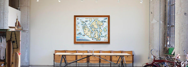 A San Juan Islands framed map over a row of chairs in a warehouse looking interior home. 
