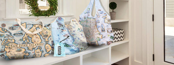 Home entry way or foyer with Xplorer Maps Tote bags. Tote bags have illustrated maps of San Juan Islands, California central coast and San Fransisco.