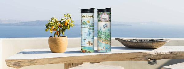 Xplorer Maps Hawaii and Sanibel & Captiva Islands Travel Drinkware Collections sitting on wood slab table by the ocean. 