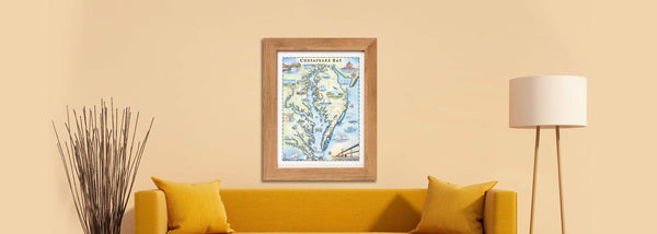 Chesapeake Bay hand-drawn map in a wood frame hanging on a tan wall above a yellow couch. 
