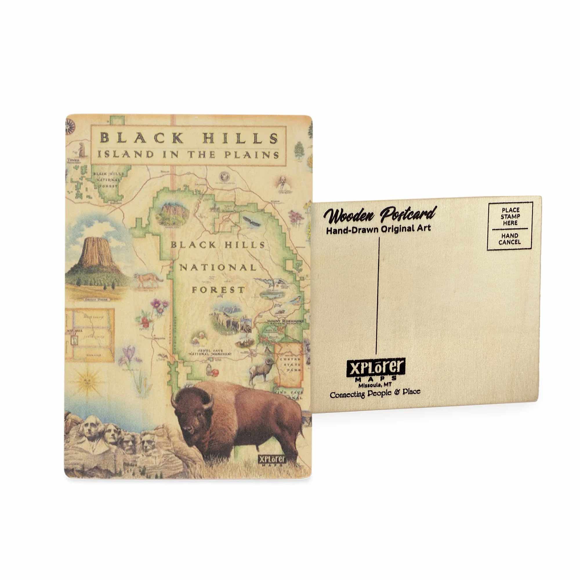 Black Hills National Forest Map wooden postcard in earth tone colors featuring hand-drawn illustrations of Mount Rushmore, Devils Tower, and native wildlife