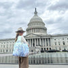 A women standing in front of the Capitol building. She is carrying  a Chesapeake Bay pouch tote bag.