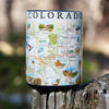 Blue 16 oz Colorado state map coffee mug sitting on a log in the forest. The map showcases various cities including Denver, Fort Collins, Colorado Springs, Aspen, and Durango. It also features local flora and fauna, such as moose, Rocky Mountain elk, turtles, eagles, and Bighorn Sheep, as well as the indigenous Navajo and Hopi peoples. The map highlights popular activities like hiking, biking, rafting, and skiing.