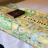 London Blanket by Xplorer Maps folded at the end of a bed with a leather journal sitting on it.