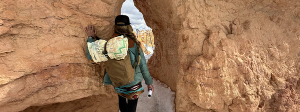 A Women At Bryce Canyon Hiking. She Has An Xplorer Maps Fleece Blanket Rolled On Top of Her Backpack.