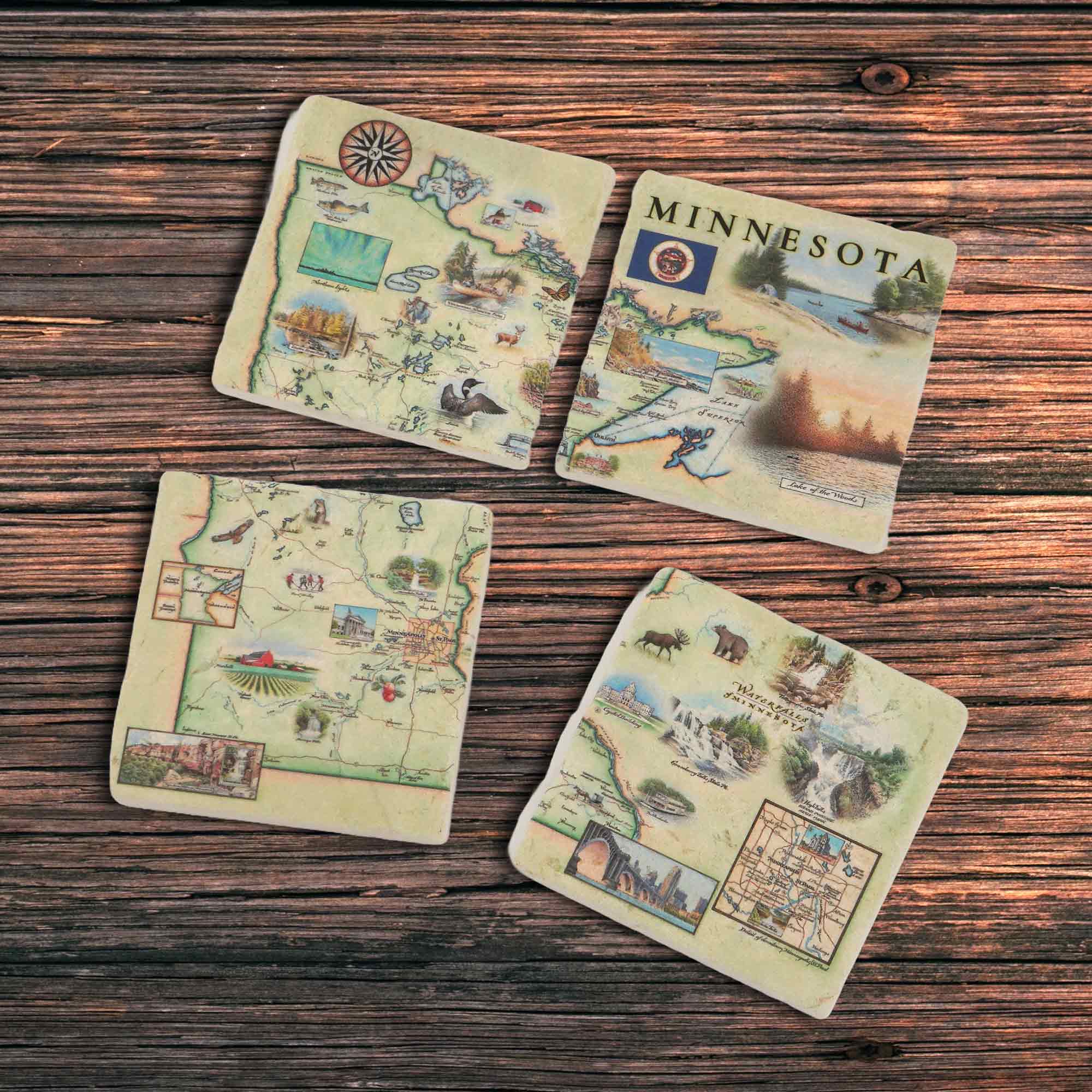 Minnesota Stone Coaster Set set of 4 on a wood table. The map showcases key landmarks including waterfalls, Lake Superior, Lake in the Woods, Split Rock Lighthouse, Paul Bunyan, Itasca State Park, and the capitol building. The design also features local w