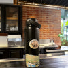 Missoula Map Wrap on a Black Stainless Steel Water Bottle. The bottle is sitting on a dark wood counter with a brick wall in background.