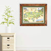 Hand-illustrated Tennessee map by Chris Robitaille, featuring landmarks such as the Smoky Mountains, Graceland, and Dollywood, highlighting Nashville, Memphis, and more. The artwork is hanging on a white wall next to a marble side table with a plant on top.