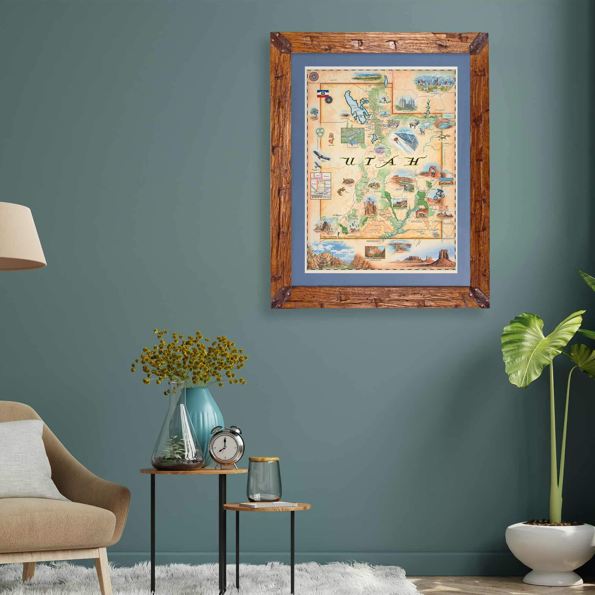 Framed Utah State Map hanging on a greenish teal wall above a plant and chair in a living room.