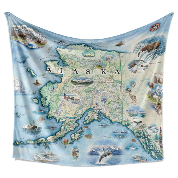 Hanging Alaska fleece blanket. The map includes Denali National Park and cities such as Anchorage, Fairbanks, and Juneau. Illustrations of wildlife matching the region: Polar bears, arctic foxes, moose, caribou, Gray wolves, Dall Sheep, wolverines, Canadian Lynx, King Salmon, Halibut, King Crab, horned puffins, harbor seals, Arctic Tern, ptarmigan, walruses, Kodiak bears, musk ox, Bald Eagles, Mountain Goats and more.