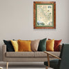 Banff National Park hand-drawn map in a Montana hand-scraped pine wood frame with green mat. The map is hanging over a couch in a living room with colorful pillows.