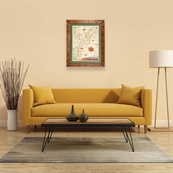 Bryce Canyon National Park Hand-Drawn Map haning on a tan wall over a yellow couch. The map is framed in Montana hand scraped pine with green mat. 