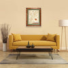 Bryce Canyon National Park Hand-Drawn Map haning on a tan wall over a yellow couch. The map is framed in Montana hand scraped pine with green mat.