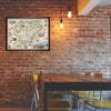 Denali National Park hand-drawn map in a black frame hanging on a brick wall over a kitchen table.