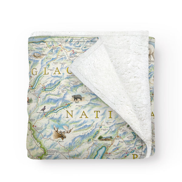 A folded blanket with a map of Glacier National Park on it. Hand-drawn artwork. Blanket measures 58"x50."