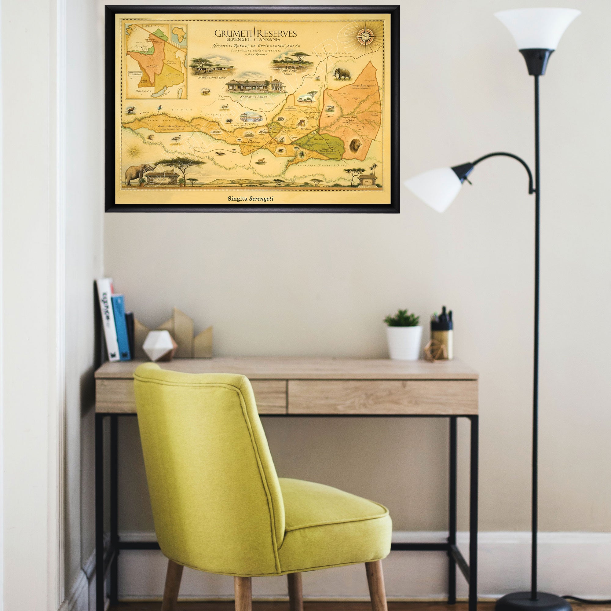 Africa's Grumeti Reserves Hand-Drawn Map in a black frame hanging over a student desk with yellow chair.
