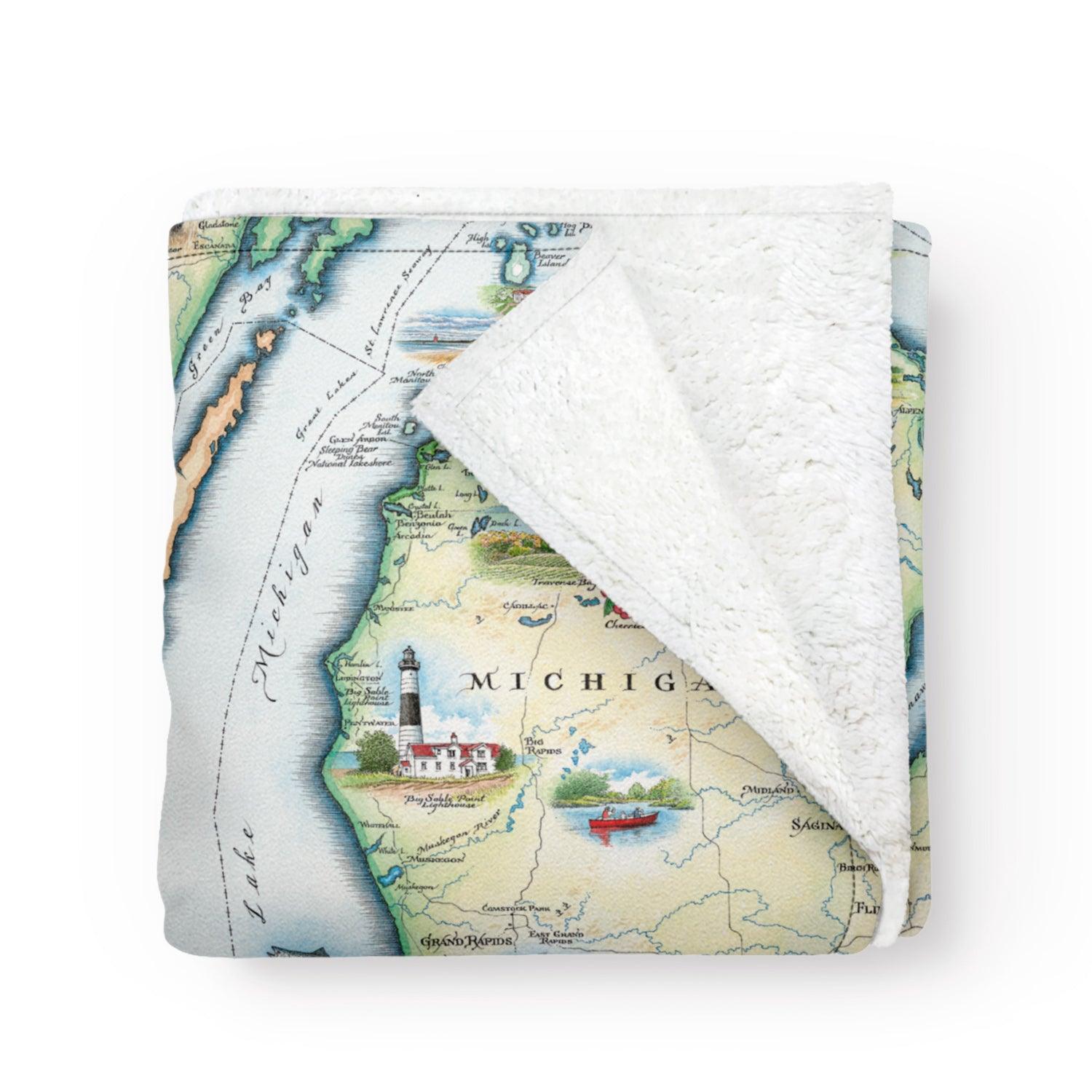 Folded blanket with a map of Michigan on it. Soft and cozy fleece blanket. Artistic map blanket. Measures 58
