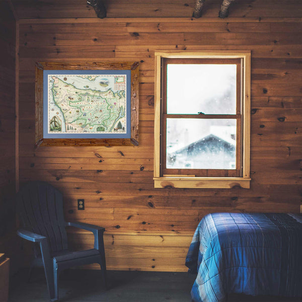 Olympic National Park Map in a Montana Pine frame with blue mat hanging in a log cabin bedroom with blue bedspread.