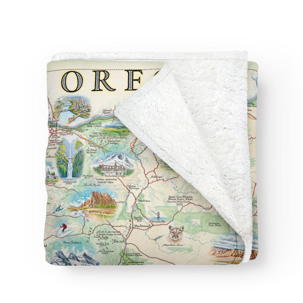 Folded fleece blanket with an Oregon state map. Hand-drawn and full-color blanket. Cozy and soft.