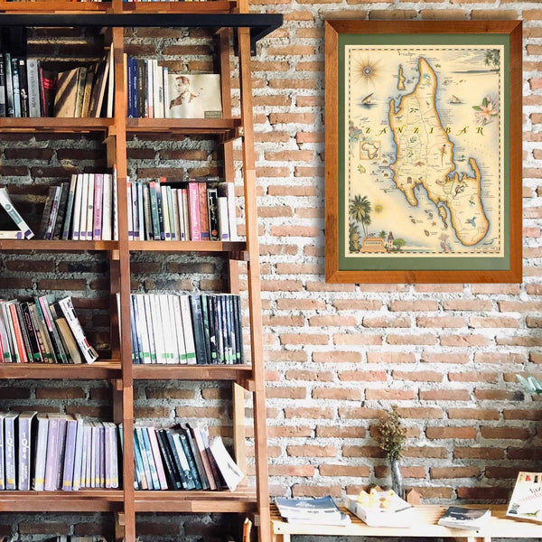 Africa's Zanzibar framed hand-drawn map is hanging on a brick wall next to a large shelf unit with a ladder.