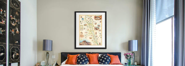 Capitol Reef National Park hand-drawn map in a black frame hanging over a bed. 