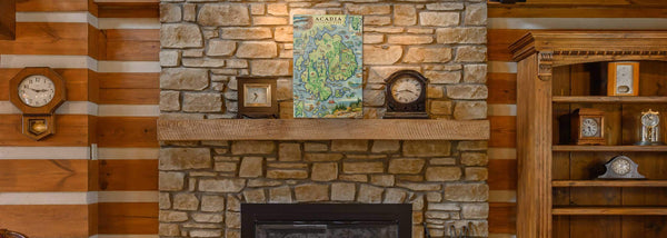 The Xplorer Maps wood sign on a wood mantle with clocks above a fireplace. 