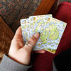 A women holding Xplorer Maps Acadia National Park Map Playing cards.