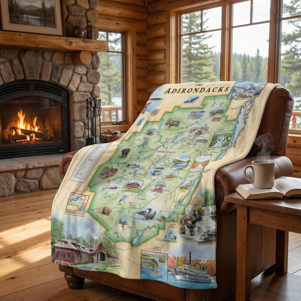 Adirondacks Map-themed blanket draped over a chair in a cozy room with a fireplace and windows.