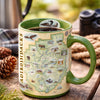 Mug with Adirondack map design on a wooden surface with nature-themed items.