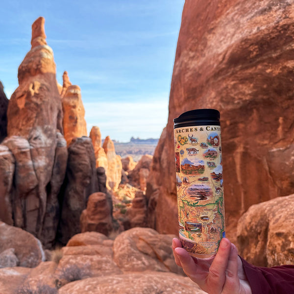  Utah's Arches & Canyonlands National Park travel drinkware in front of rock formation inside the park. 