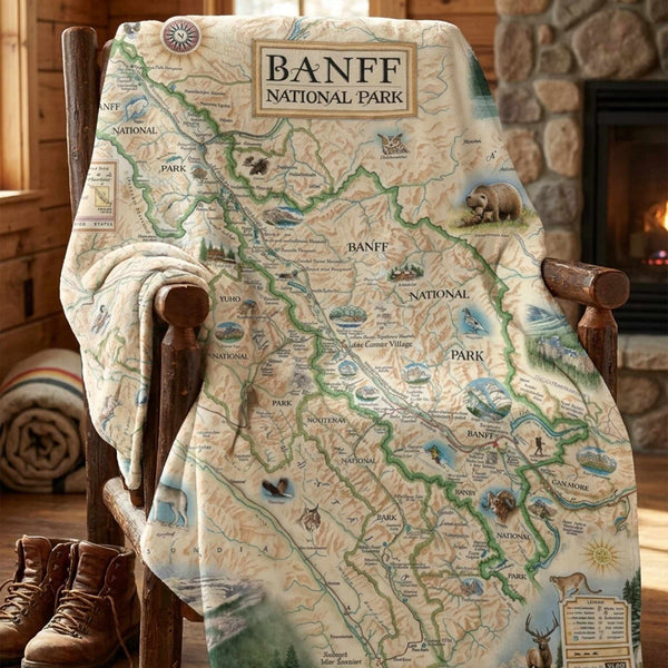Map-themed blanket with Banff National Park design draped over a chair in a cozy room.
