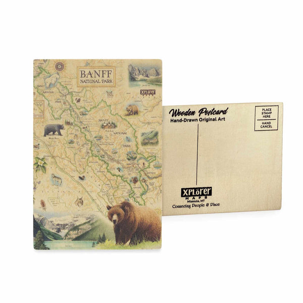 Banff National Park Map wooden postcard in earth tone colors featuring hand-drawn illustrations of Canadian Rockies, Lake Louise, and native wildlife.
