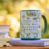 Mug with Black Hills National Forest design on a book with a blurred natural background