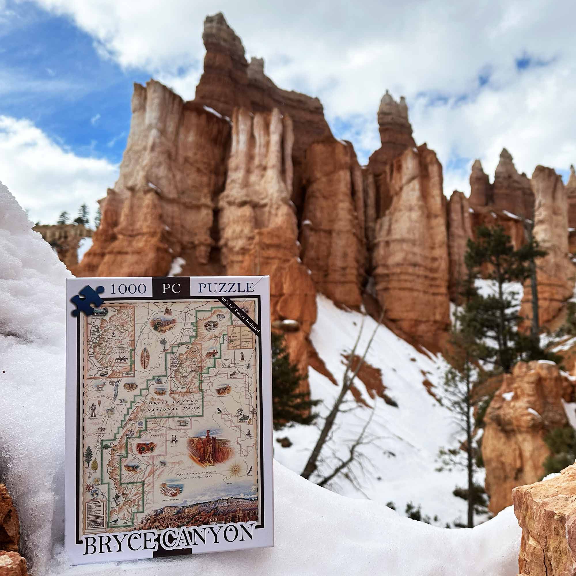 A 1000-piece jigsaw puzzle titled 'Bryce Canyon' with a vintage map design, displayed in the snow with a real Bryce Canyon landscape in the background.