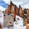 A 1000-piece jigsaw puzzle titled 'Bryce Canyon' with a vintage map design, displayed in the snow with a real Bryce Canyon landscape in the background.