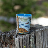 Xplorer Maps shot glass of California Central Coast State Parks sitting on a tree stump.  Fsea life, birding, and terrestrial creatures. Cultural history is rich in the area with the fame of Hearst Castle, Ranchers of Montana De Oro, Dunites of Oceano Dunes, and Native people that have lived on this land for thousands of years from San Francisco to Los Angeles. See butterflies, bears, seals, otters, whales, and more!