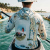 Person wearing a Cape Cod map-themed sun shirt on a boat in a body of water with trees in the background