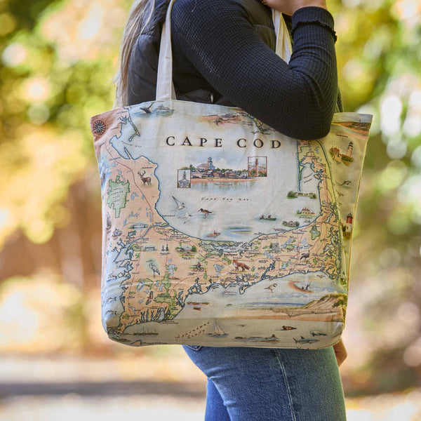 Person holding a tote bag with a map design of Cape Cod.