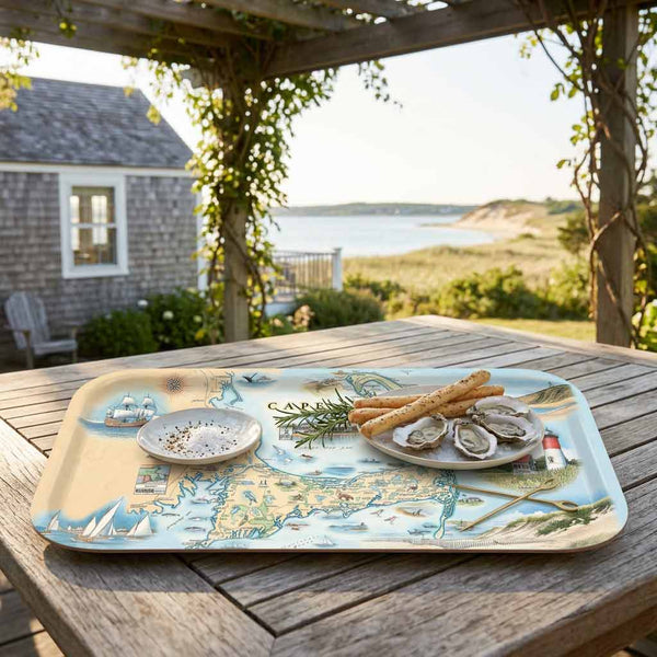 Decorative map tray of Cape Cod with food on a wooden table outdoors, featuring a scenic design.