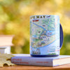 Cup with Cape May map design on a book with a blurred natural background