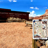 A jigsaw puzzle box labeled '1000 PC PUZZLE' and 'CAPITOL REEF' is shown in the foreground on a wooden post, with a Capitol Reef National Park sign and desert landscape in the background under a blue sky.