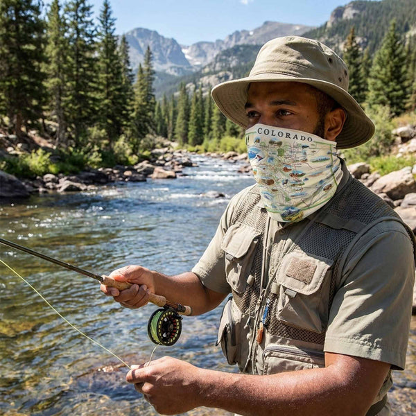 Man fly fishing in a mountainous area with a Colorado-themed sun gaiter