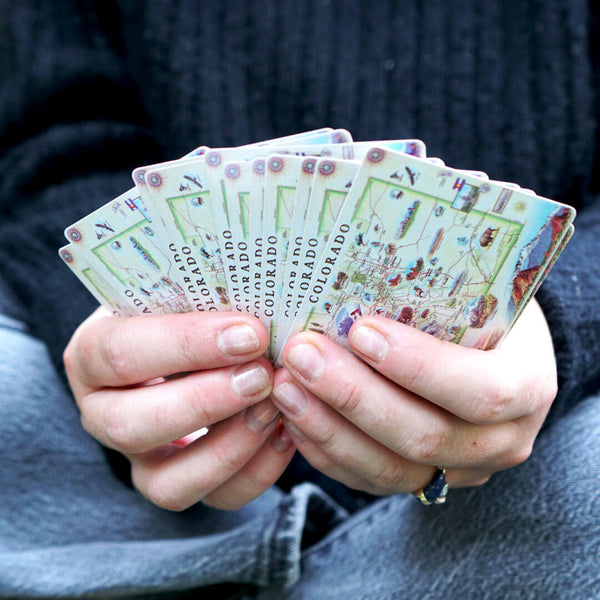 A person holding a hand of Colorado Map Playing Cards. 