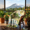 Map of Costa Rica blanket draped over a chair with a scenic view outside.