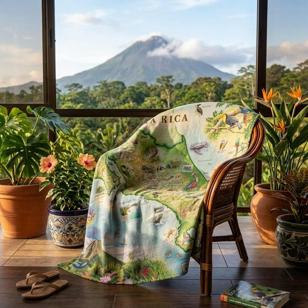 Map of Costa Rica blanket draped over a chair with a scenic view outside.