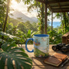 Mug with Costa Rica design on a wooden table with binoculars and notebook, set against a scenic backdrop.