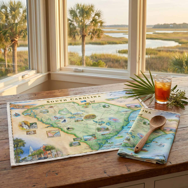 Dish Towel Map of South Carolina on a table with a scenic view through windows.