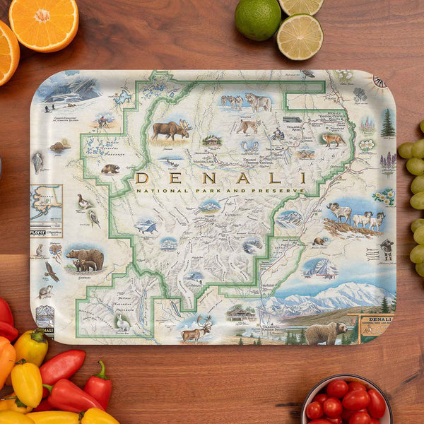 Map of Denali National Park and Preserve on a wooden cutting board with fruits and vegetables around.